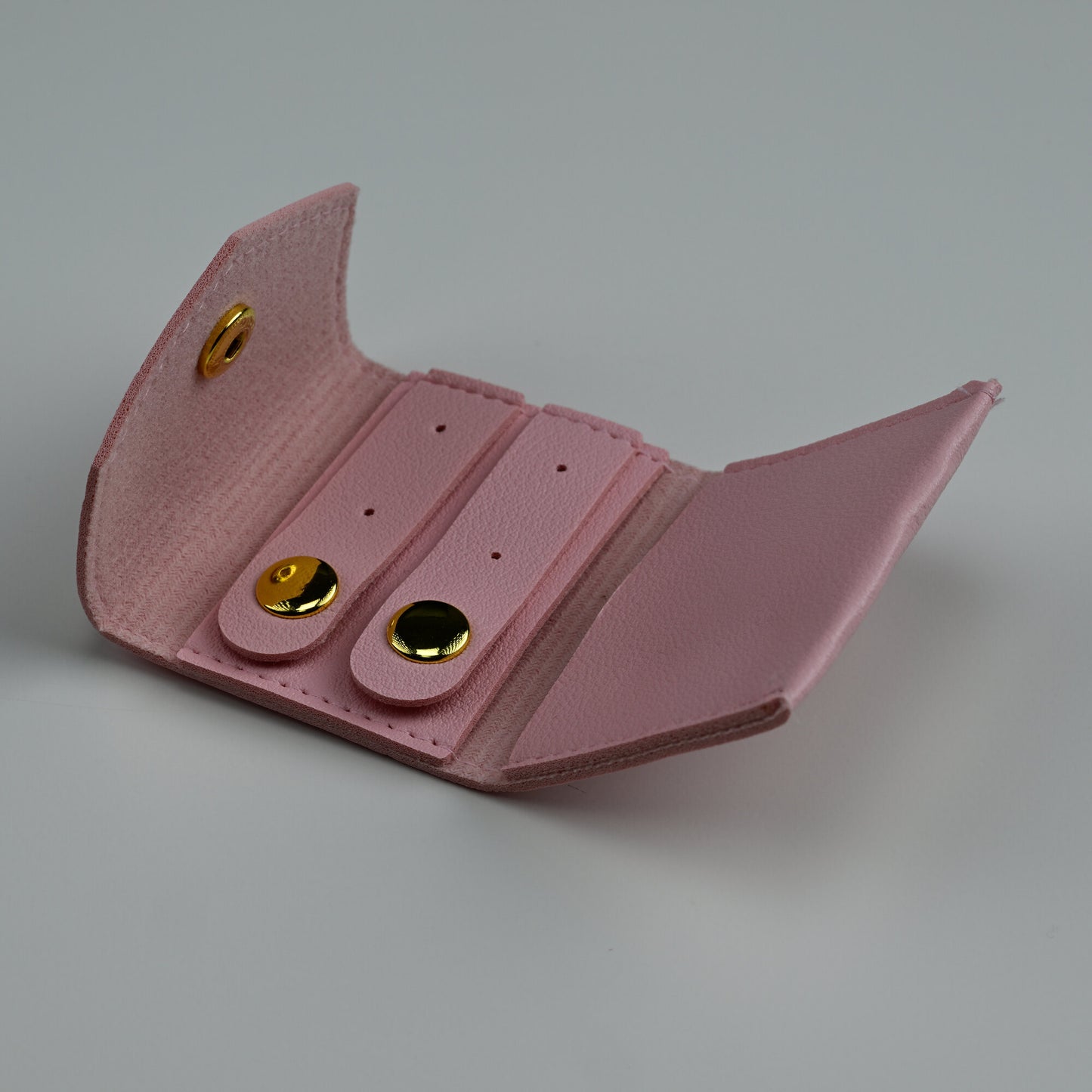Open pink envelope jewellery pouch showing snap tabs for rings and studs