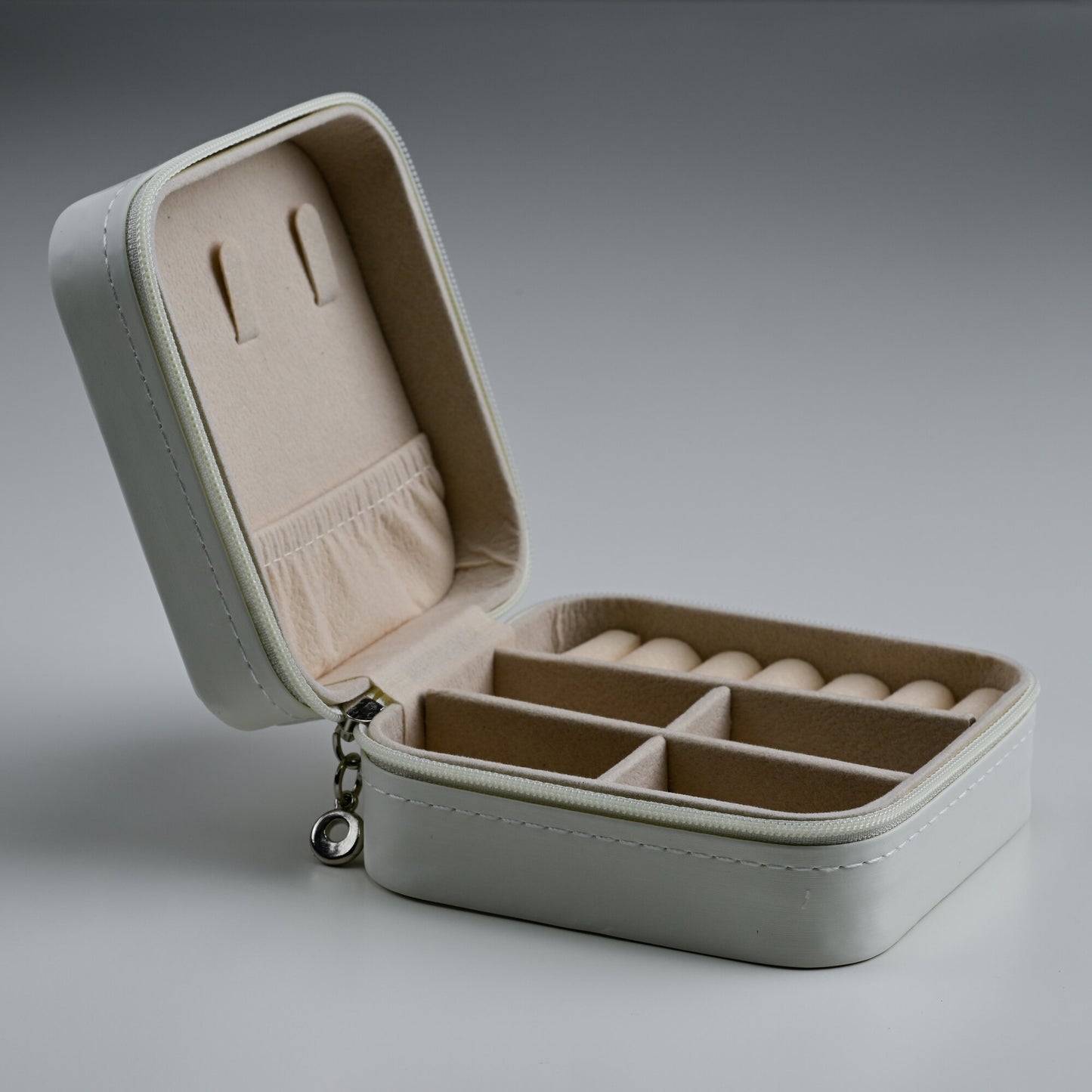 Open white leather travel jewellery box with ring rolls and lid pocket