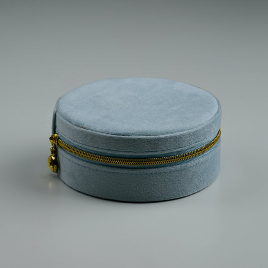Dusty blue round velvet jewellery box with gold zip, closed
