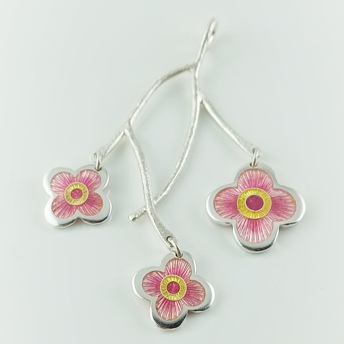 Three cherry blossom enamel flowers on a silver branch