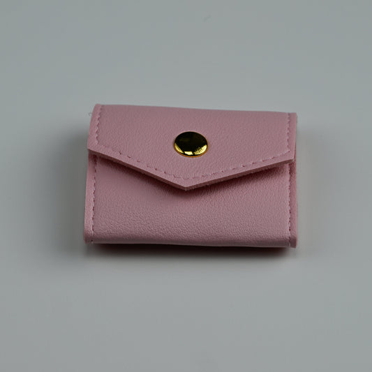 Pink faux-leather envelope jewellery pouch with gold snap, closed