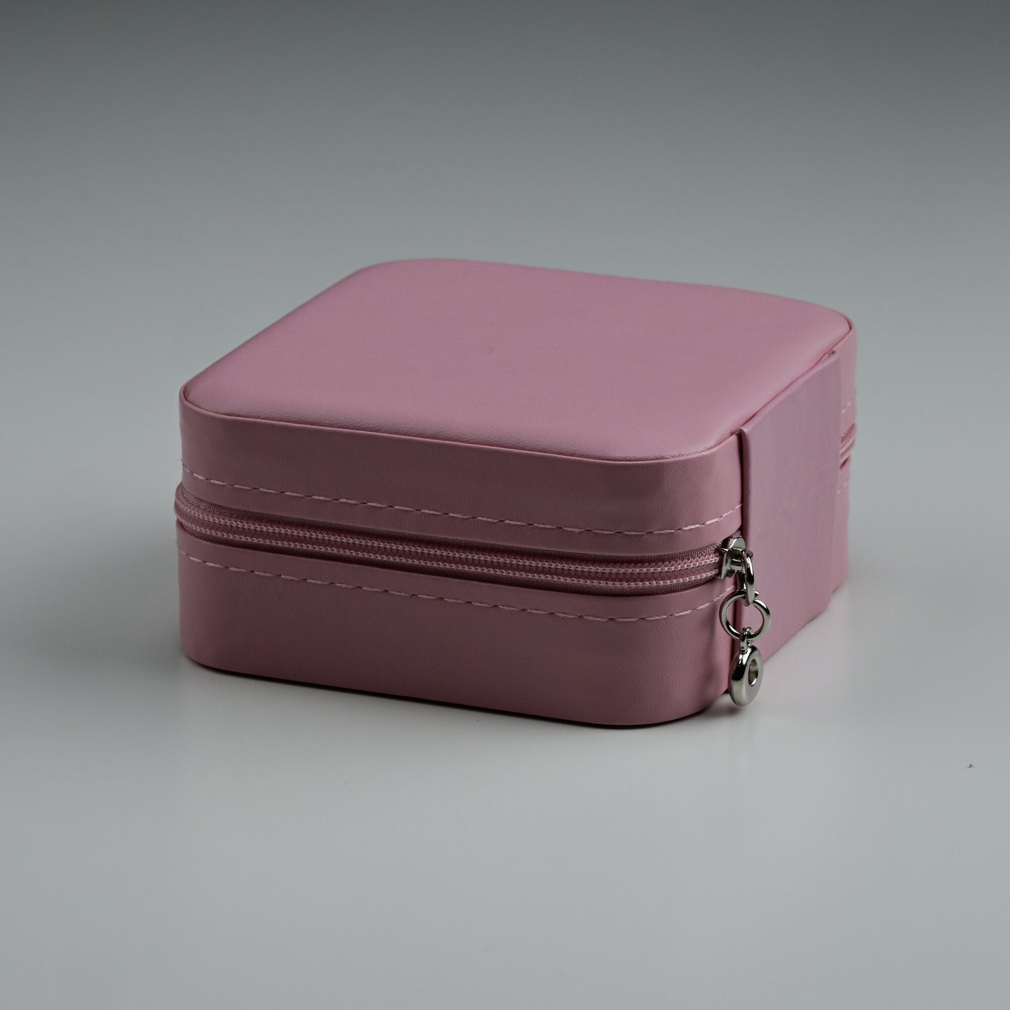 Pink faux-leather travel jewellery box with silver zip, closed