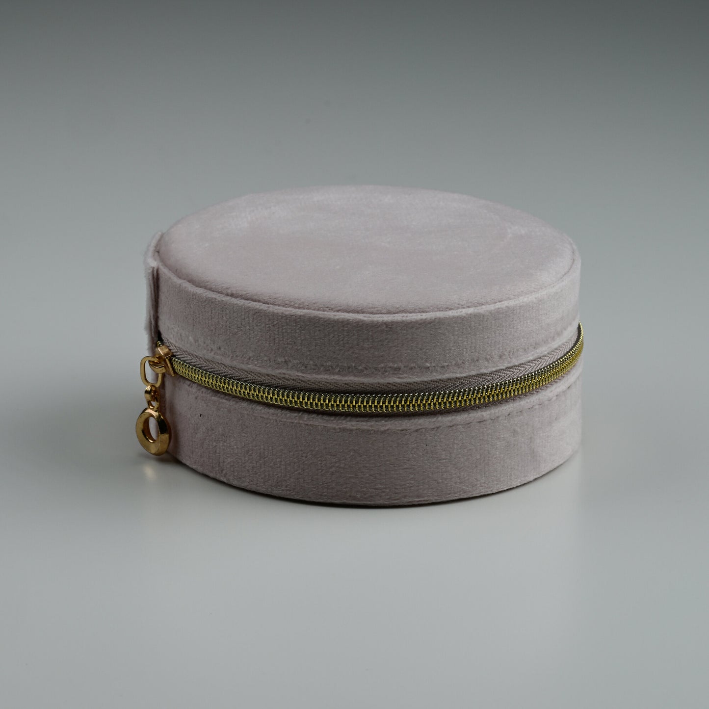Blush round velvet jewellery box with gold zip, closed