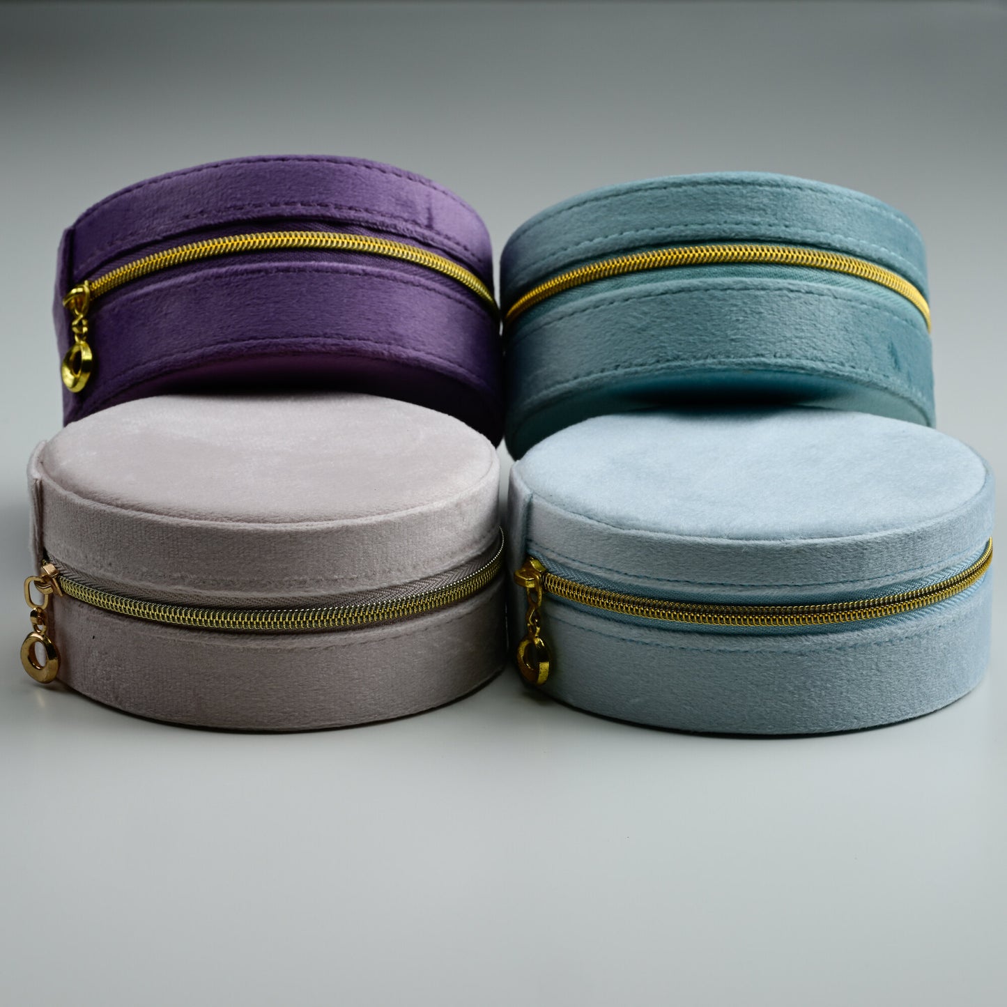 Four NJewellery round velvet jewellery boxes in dusty blue, teal, blush and purple