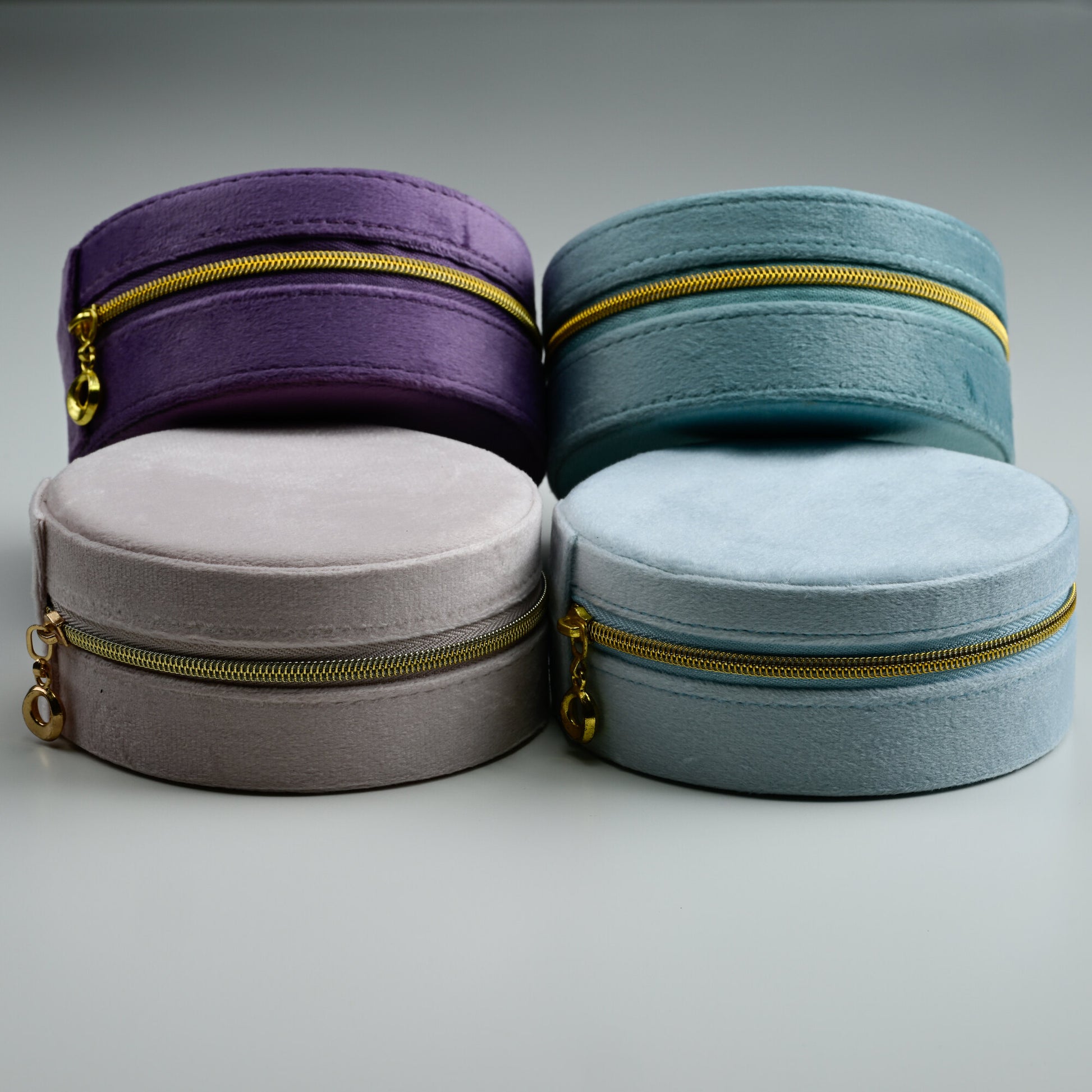 Four NJewellery round velvet jewellery boxes in dusty blue, teal, blush and purple