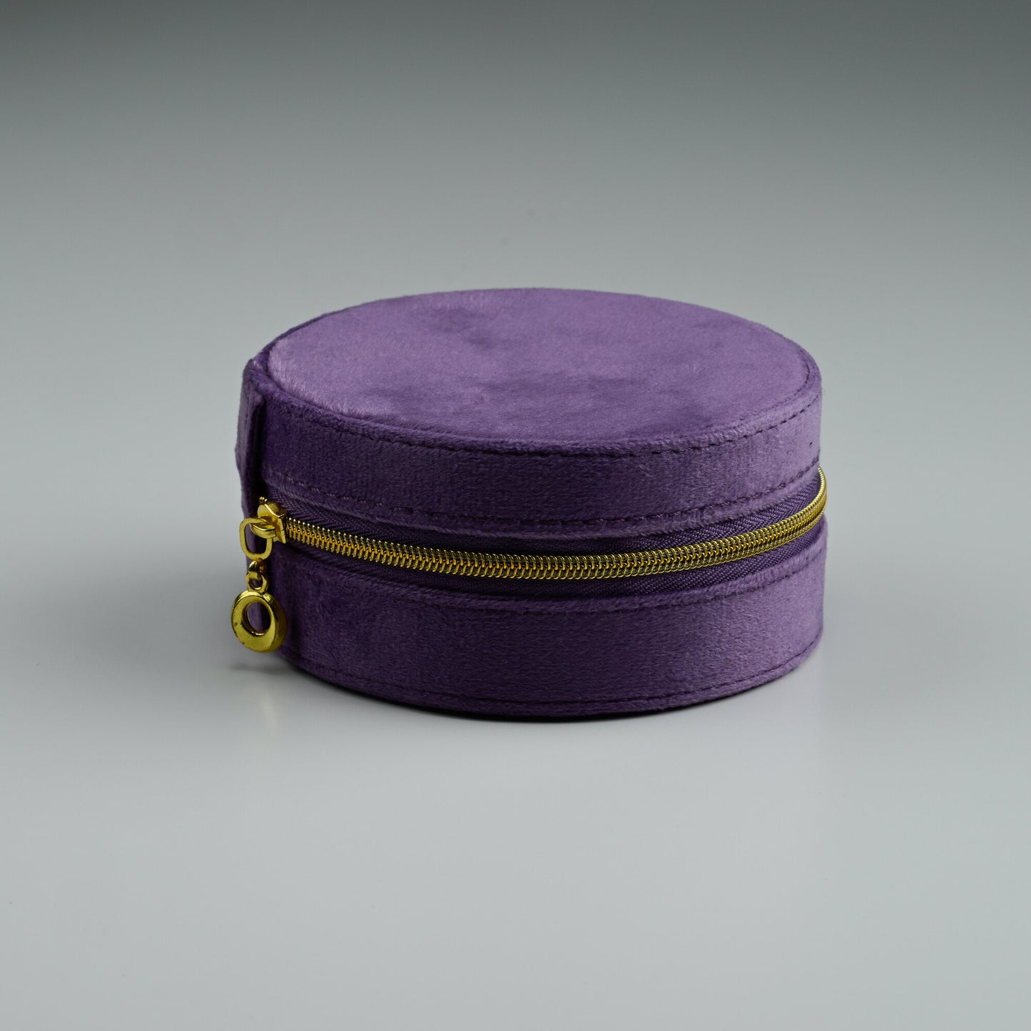 Purple round velvet jewellery box with gold zip, closed