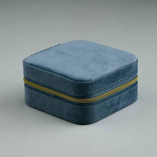 Dusty blue square velvet travel jewellery box with gold zip, closed