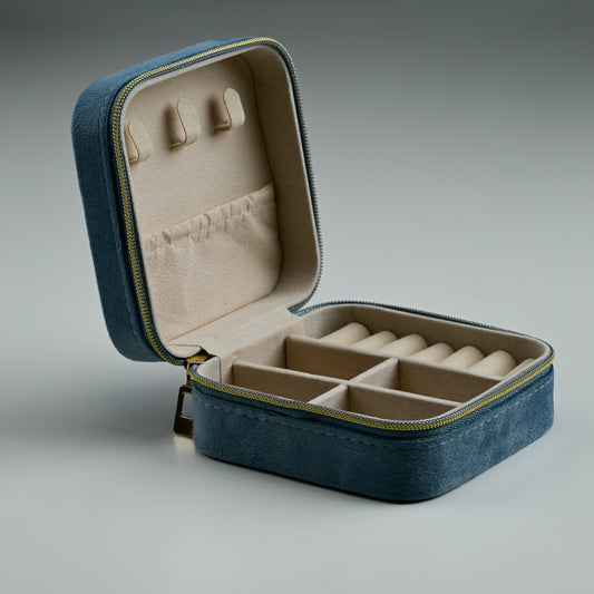 Open dusty blue velvet travel jewellery box with ring rolls and padded lid